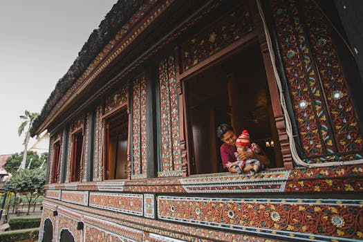 一位父亲在一座装饰复杂的传统建筑中抱着他的孩子，展示文化建筑