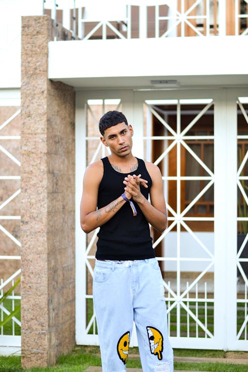 Young Man in a Casual Trendy Outfit Standing Outdoors 