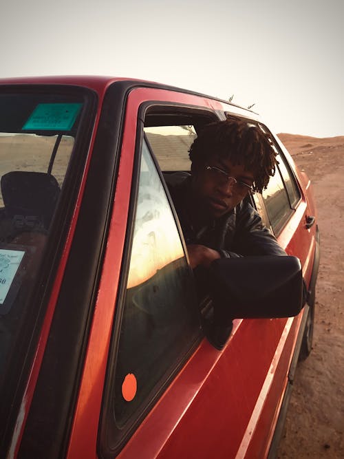 Young Man Looking Out the Window of a Car on a Desert 