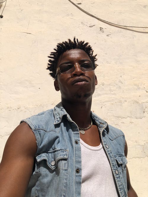 Young Man in a Denim Vest and Sunglasses