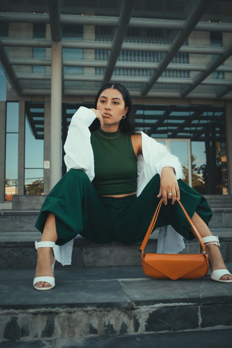 Young Fashionable Woman Sitting On Steps In City 