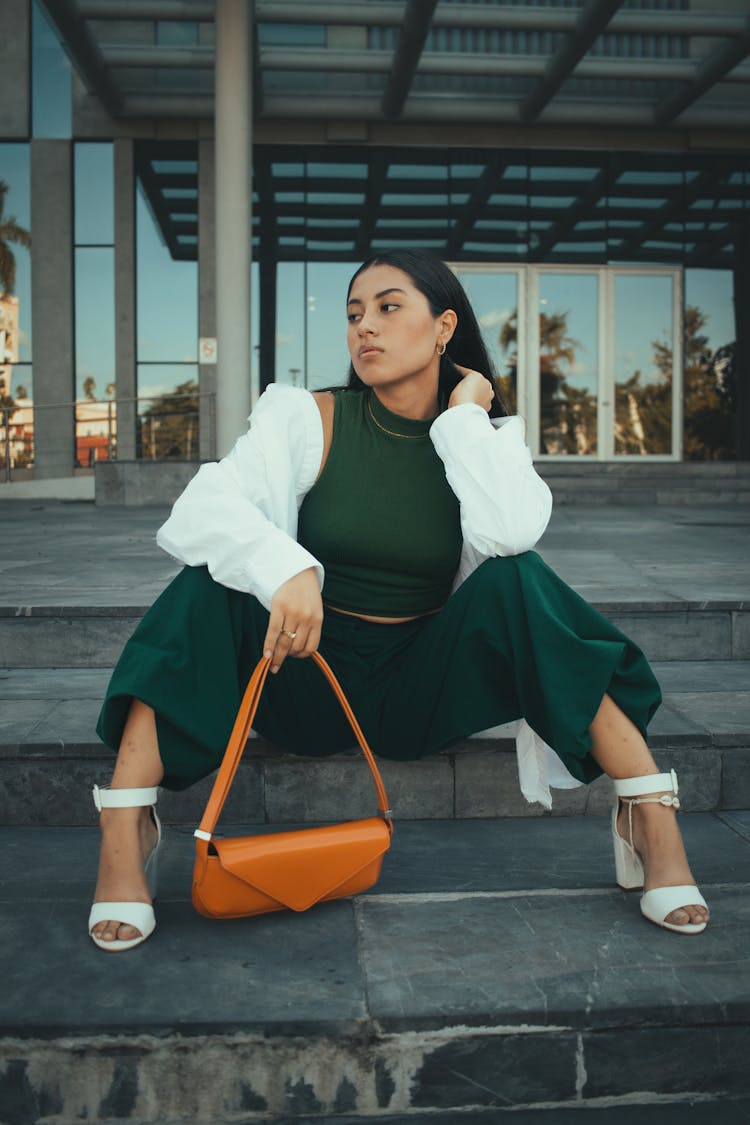 Young Fashionable Woman Sitting On Steps In City 