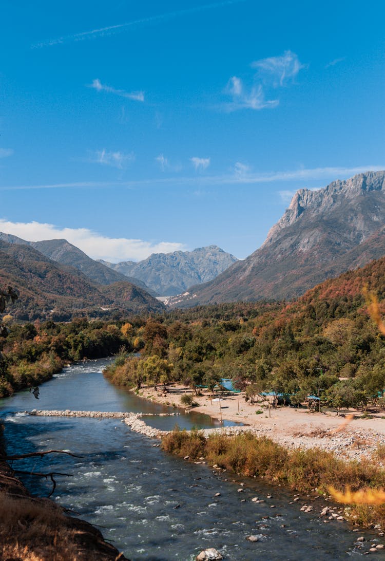 River In A Valley And Mountains In The Distance 