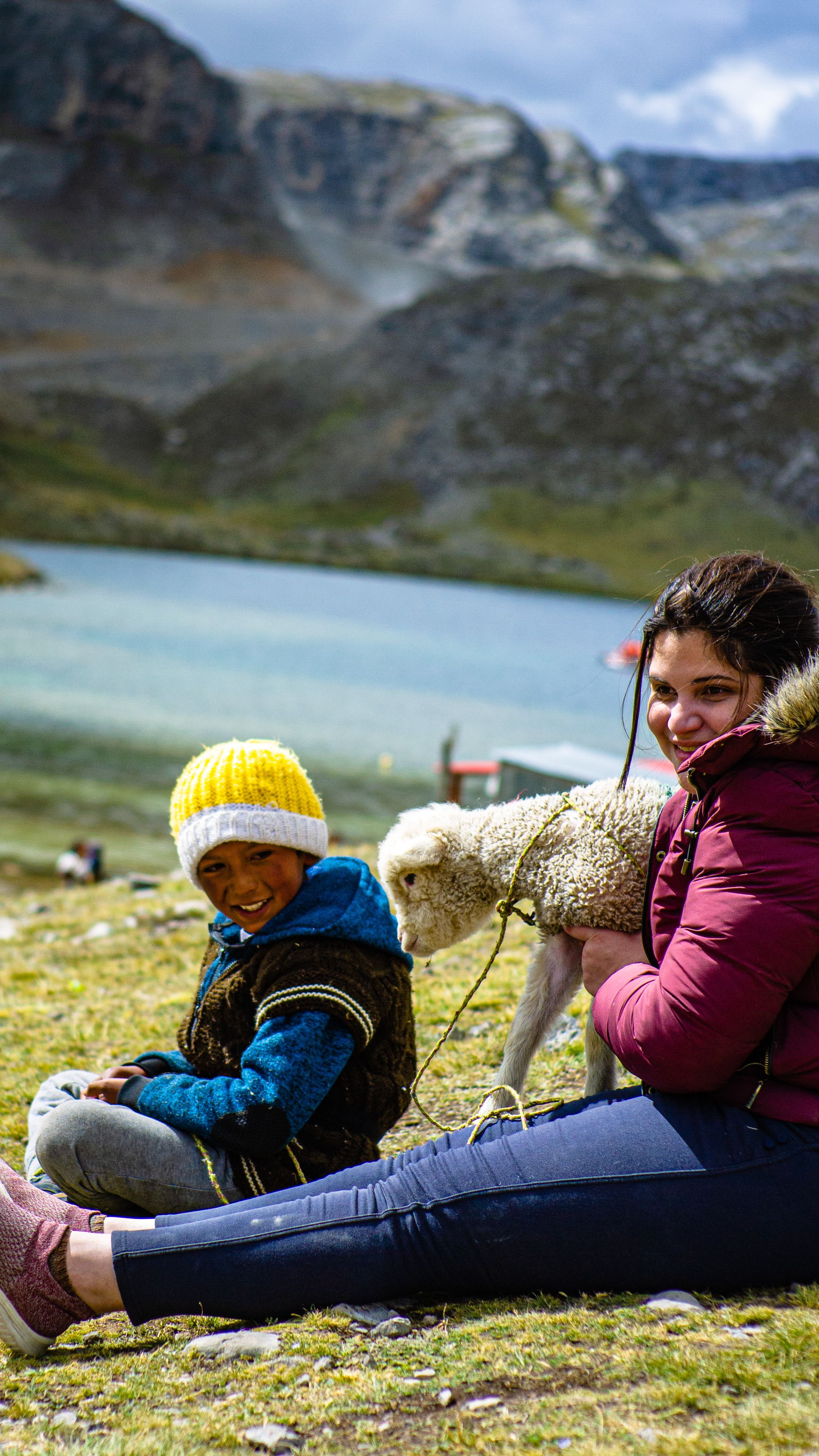 A Woman and a Little Boy Sitting on the Field with a Lamb · Free Stock ...