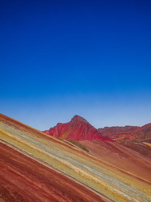 Experience the vibrant colors of Rainbow Mountain in Cusco, Peru against a clear blue sky.