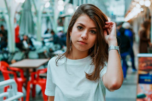 年轻女子在城市市场穿着休闲白衬衫摆姿势