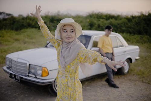 Young Woman and Man Standing next to a Vintage Mercedes on a Field 