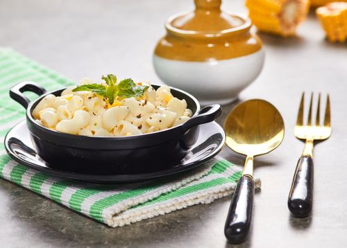 Free A delectable dish of creamy white sauce macaroni served in a black bowl, perfect for a classic and tasty meal. Stock Photo