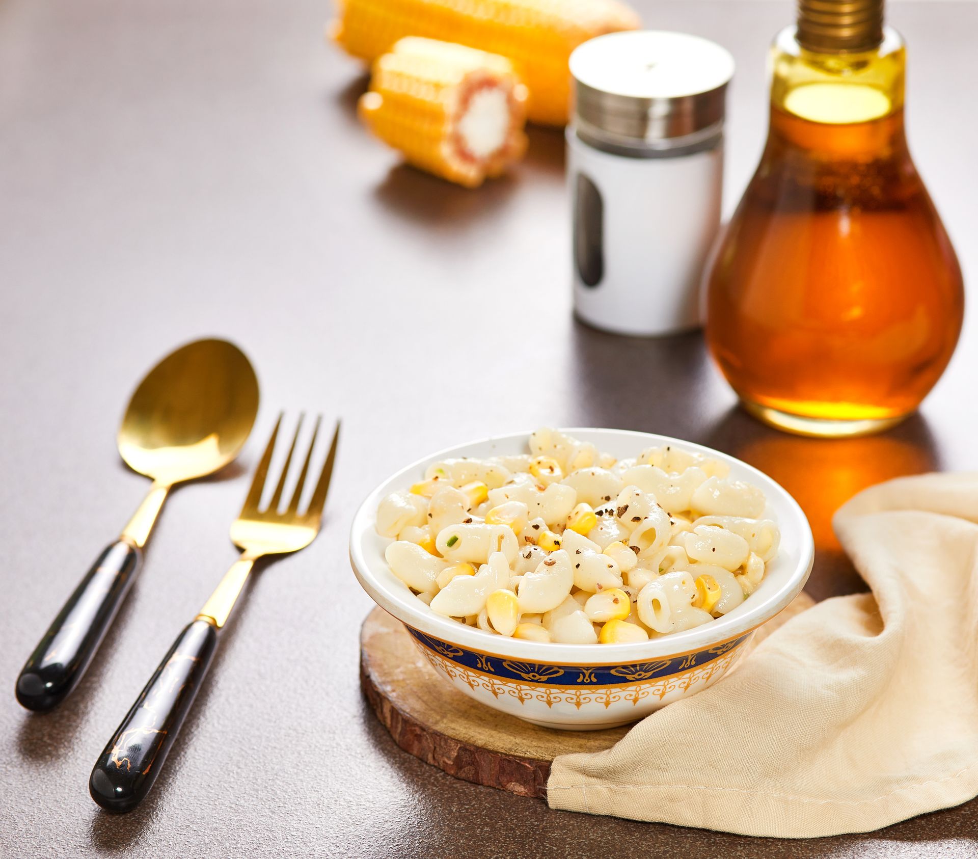 Delicious creamy macaroni with corn and spices, captured on a rustic wooden background.