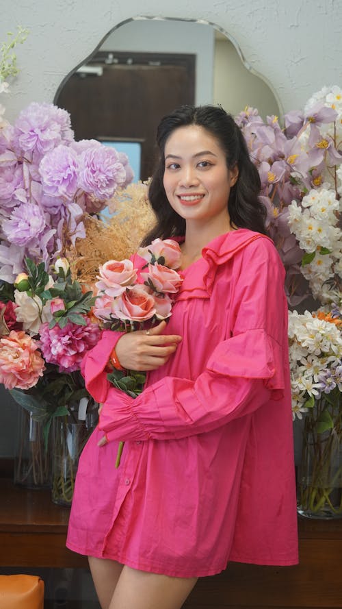 A Woman in a Pink Blouse Surrounded by Flowers