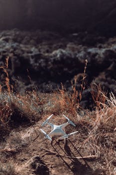 Aerial drone resting on rugged terrain in natural setting, emphasizing exploration.