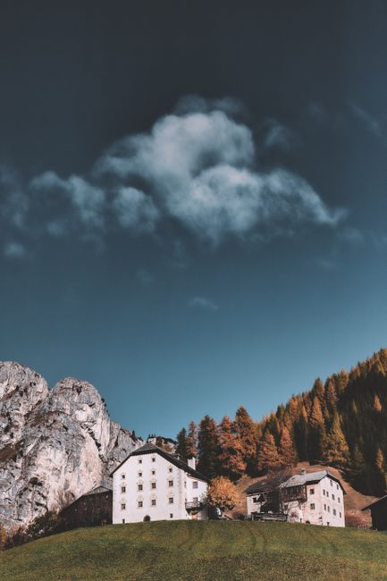 Scenic view of rustic houses against mountain backdrop with clear autumn skies.