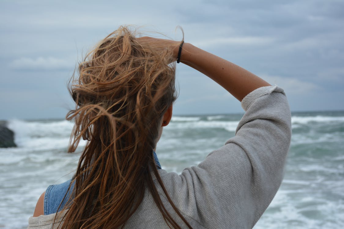 無料 日中に海に直面している女性 写真素材