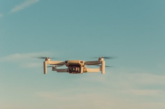 A drone hovering beneath a clear blue sky, showcasing modern technology and innovation.