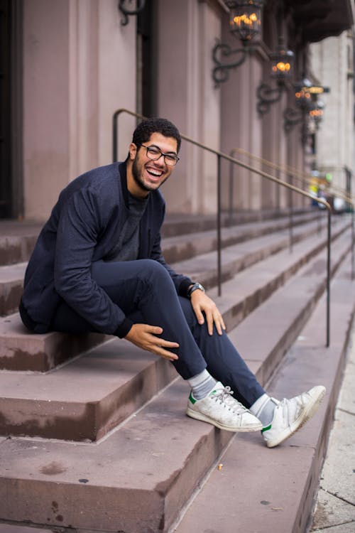 Ücretsiz Gülümserken Merdiven üzerinde Oturan Adam Stok Fotoğraflar