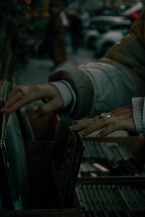 Hands of a Woman Browsing Music CDs in a Store