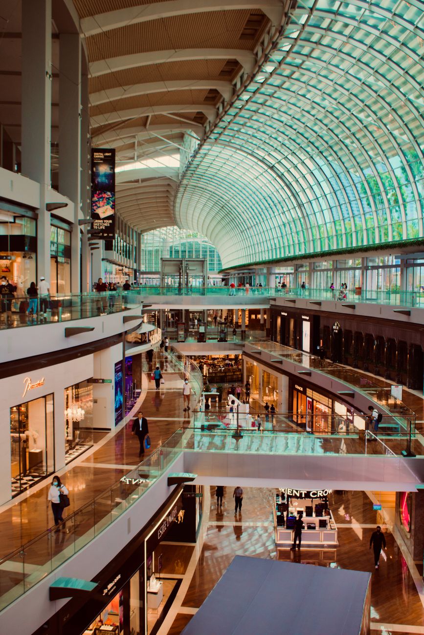 Explore the vibrant interior of a modern shopping mall in Singapore with a stunning skylight.