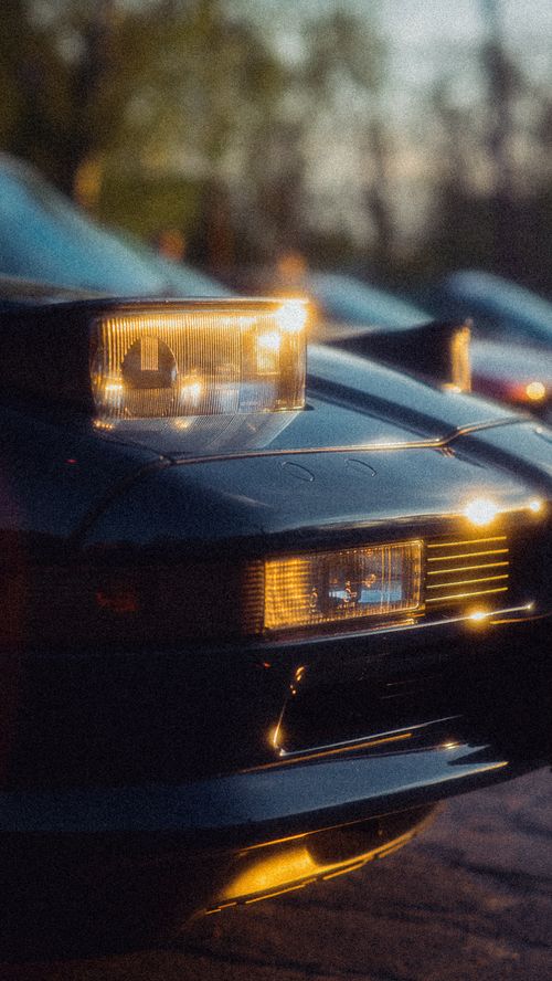 Free Close-up of classic car headlights capturing warm evening glow with vintage style. Stock Photo