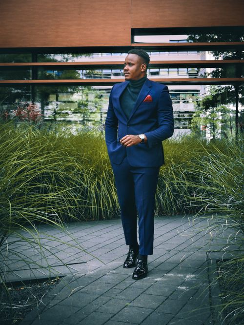 Free Stylish man in a blue suit stands confidently outdoors in an urban setting. Stock Photo