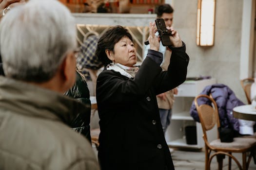 Asian woman using smartphone to take photos in an indoor urban setting.