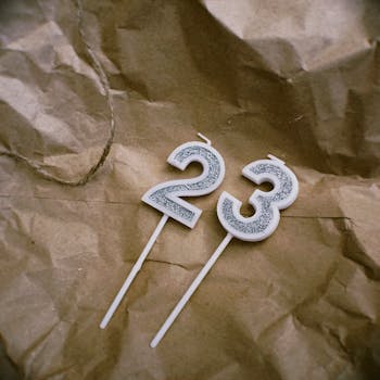 Close-up of 23 glittery number candles on brown crumpled paper background