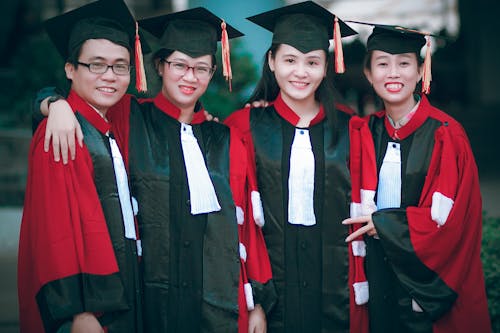 Free Man and Women Wearing Red-and-black Academic Gowns and Black Mortar Boards Stock Photo
