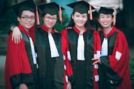 Man and Women Wearing Red-and-black Academic Gowns and Black Mortar Boards