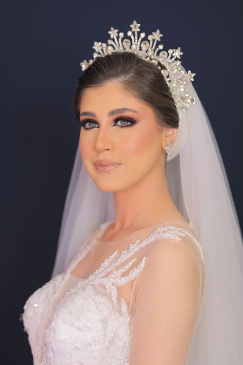 Free Beautiful bride posing gracefully with a bejeweled tiara and veil, showcasing elegance and style. Stock Photo