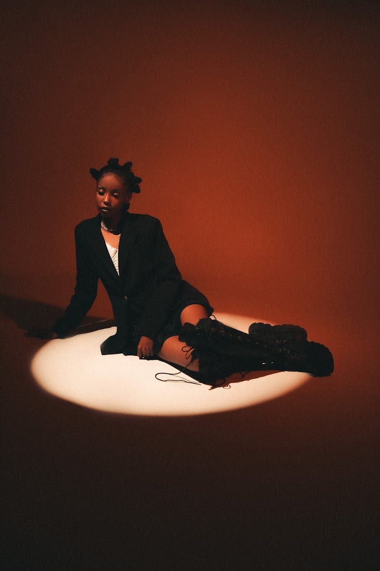 Young Woman In A Black Outfit Posing In Studio In A Spotlight 