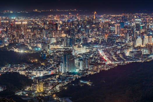 A breathtaking aerial view of a bustling cityscape at night with illuminated buildings and vibrant street lights.