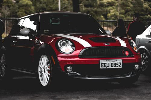 Free Red Mini Cooper with white stripes parked outdoors, showcasing a sporty design. Stock Photo
