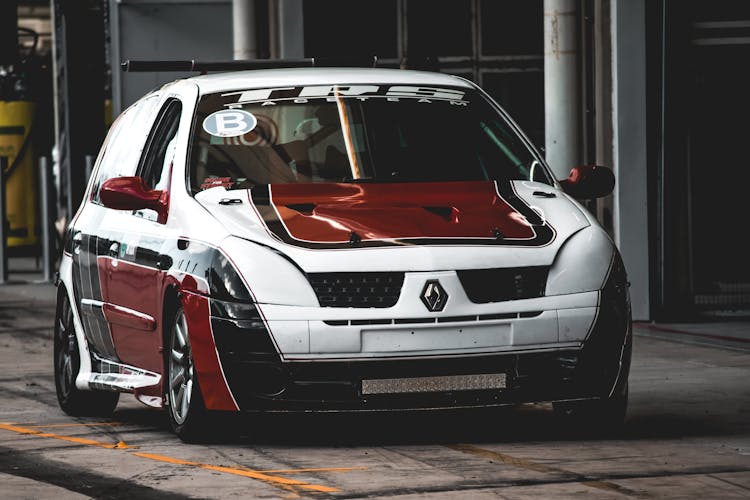 Red-White-Black Renault Clio Race Car Parked On A Street