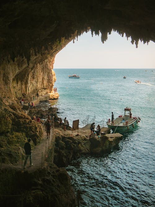 People and Boat in Bay in Cave