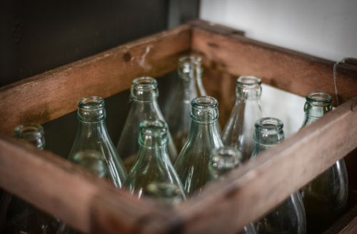 Glass bottles packed in a wooden crate, photo by ClickerHappy on Pexels