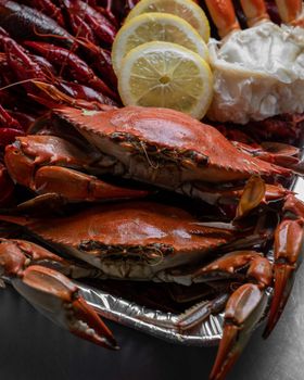 Close-up of a crab and seafood platter with sliced lemons, ideal for culinary themes.
