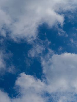 Vibrant blue sky filled with soft, fluffy white clouds creating a serene atmosphere.