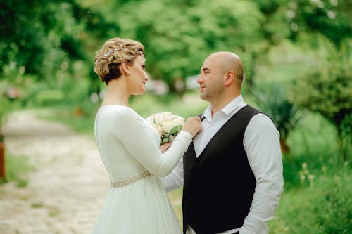 Bride and Groom Standing Outdoors and Looking at Each Other 