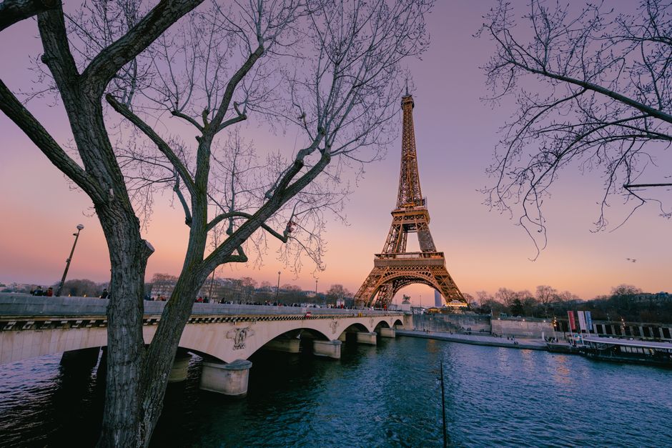 Scenic view of the Eiffel Tower at twilight from a riverside in Paris.