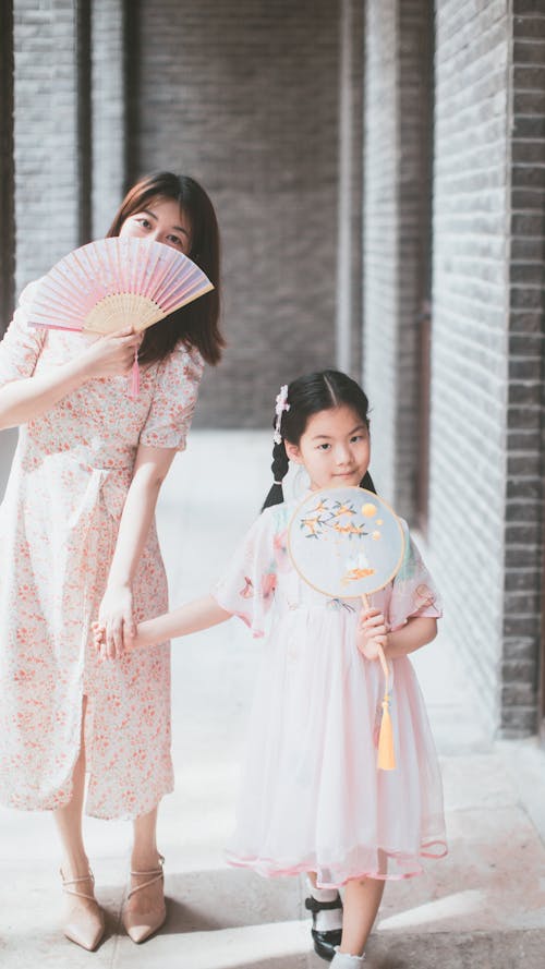 Mother and Daughter Posing in Traditional Clothing and with Fans