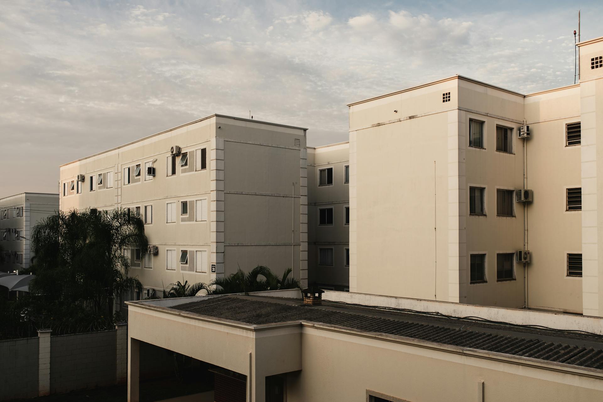 Contemporary apartment complexes under a cloudy sky showcasing urban residential architecture.