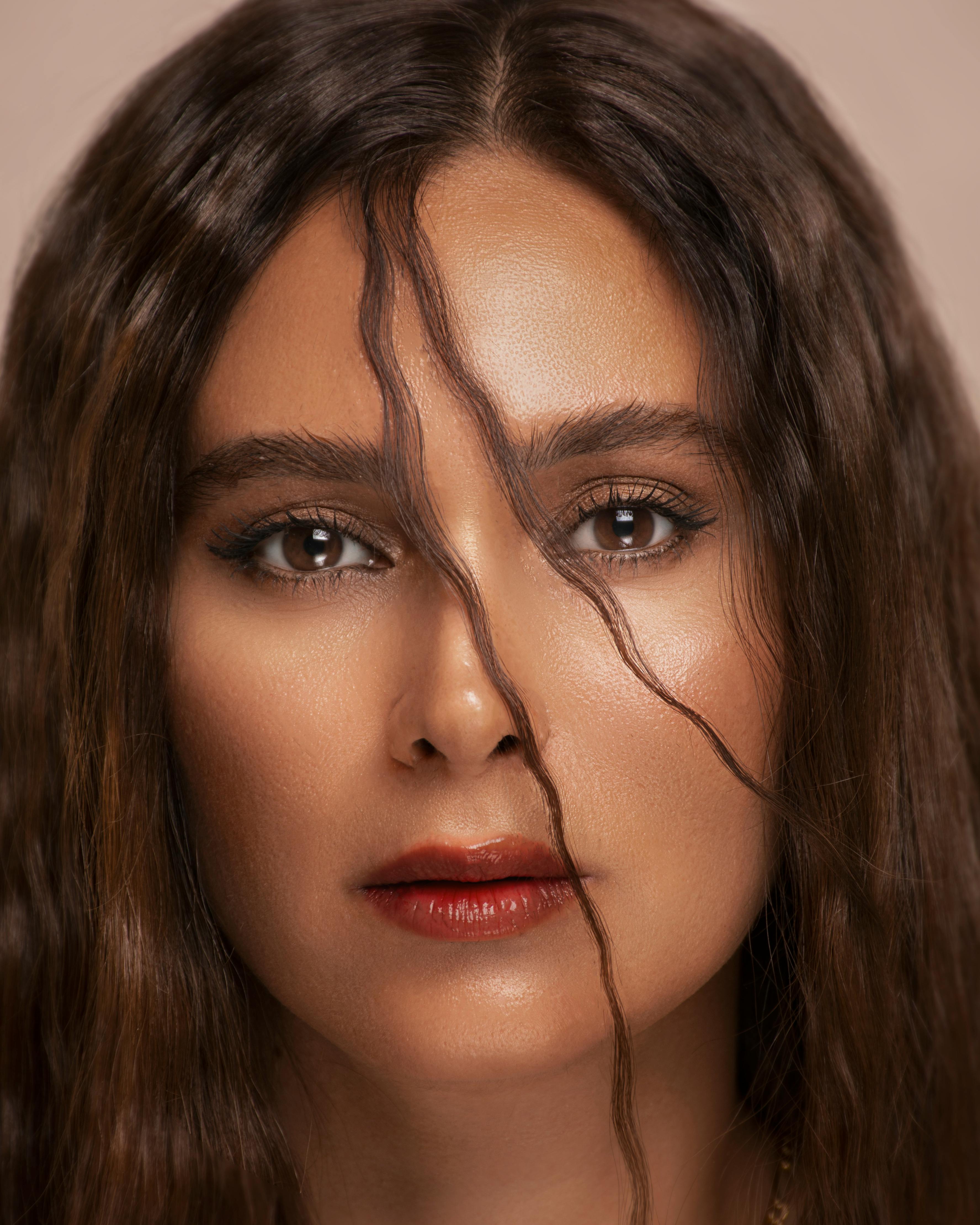 Elegant close-up portrait of a woman with cascading brunette hair and captivating eyes.