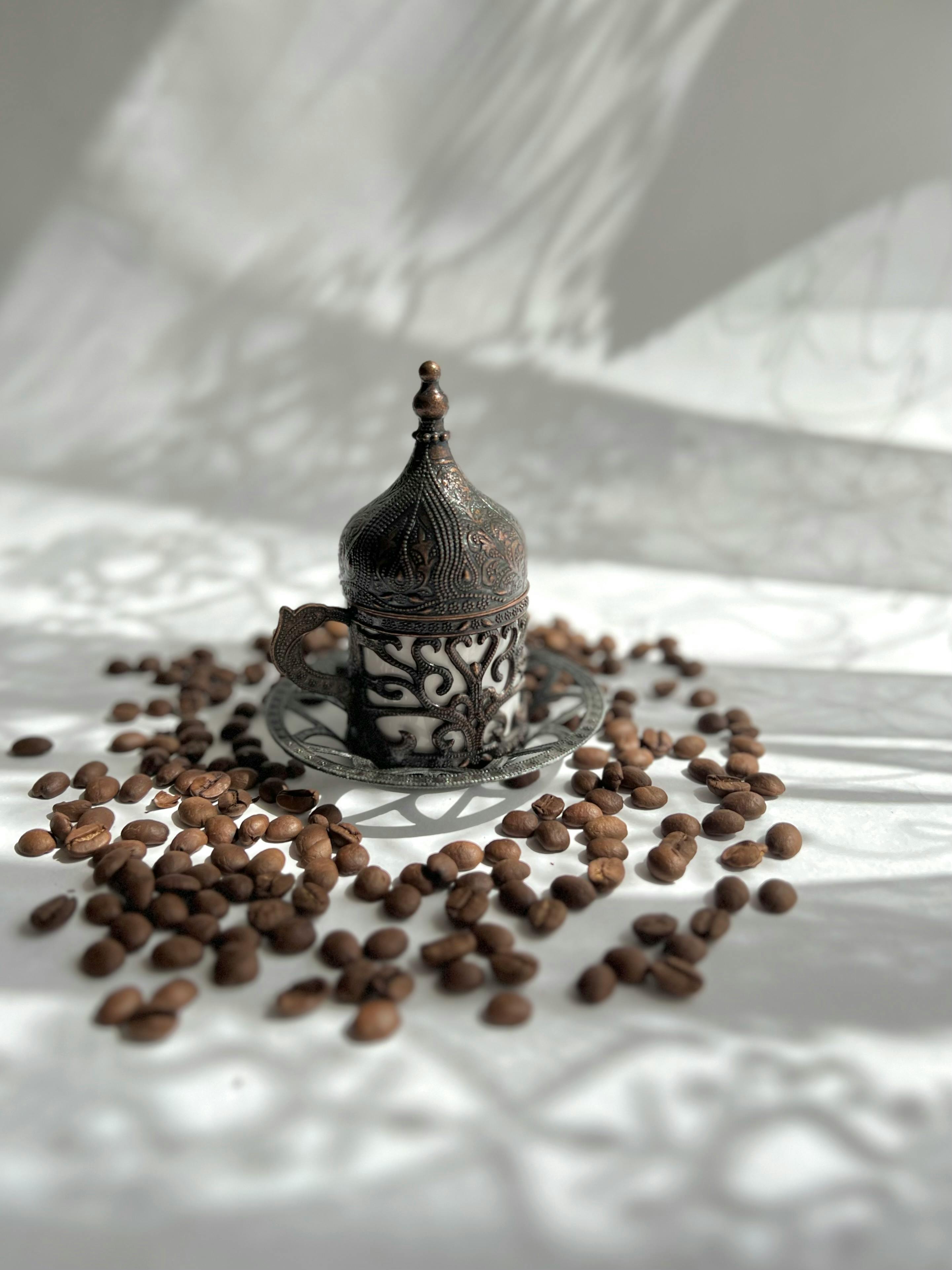 porcelain and metal traditional turkish cup among coffee beans