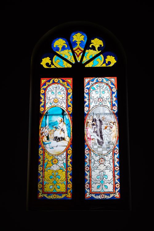 Free Vibrant stained glass window depicting religious scenes in a historic cathedral. Stock Photo