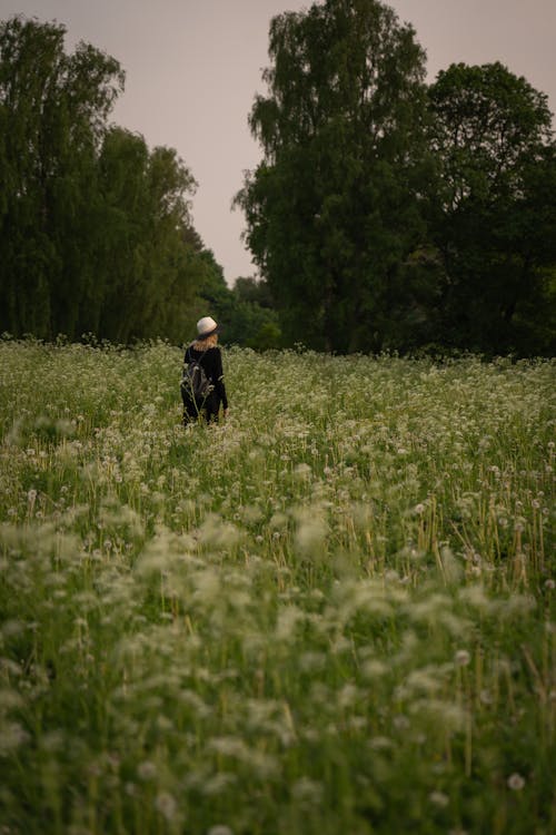 Woman Standing on a Grass Field in Summer 