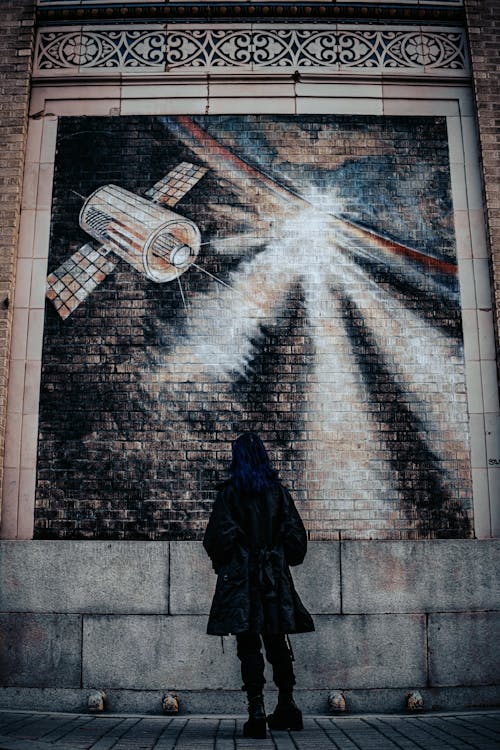 A woman standing in front of a mural of a rocket