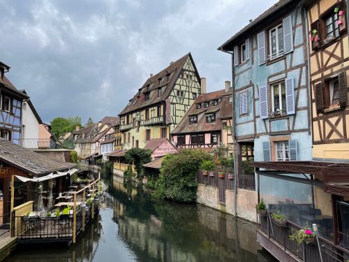 Free Charming medieval townhouses reflecting on a serene canal in Colmar, France. Stock Photo