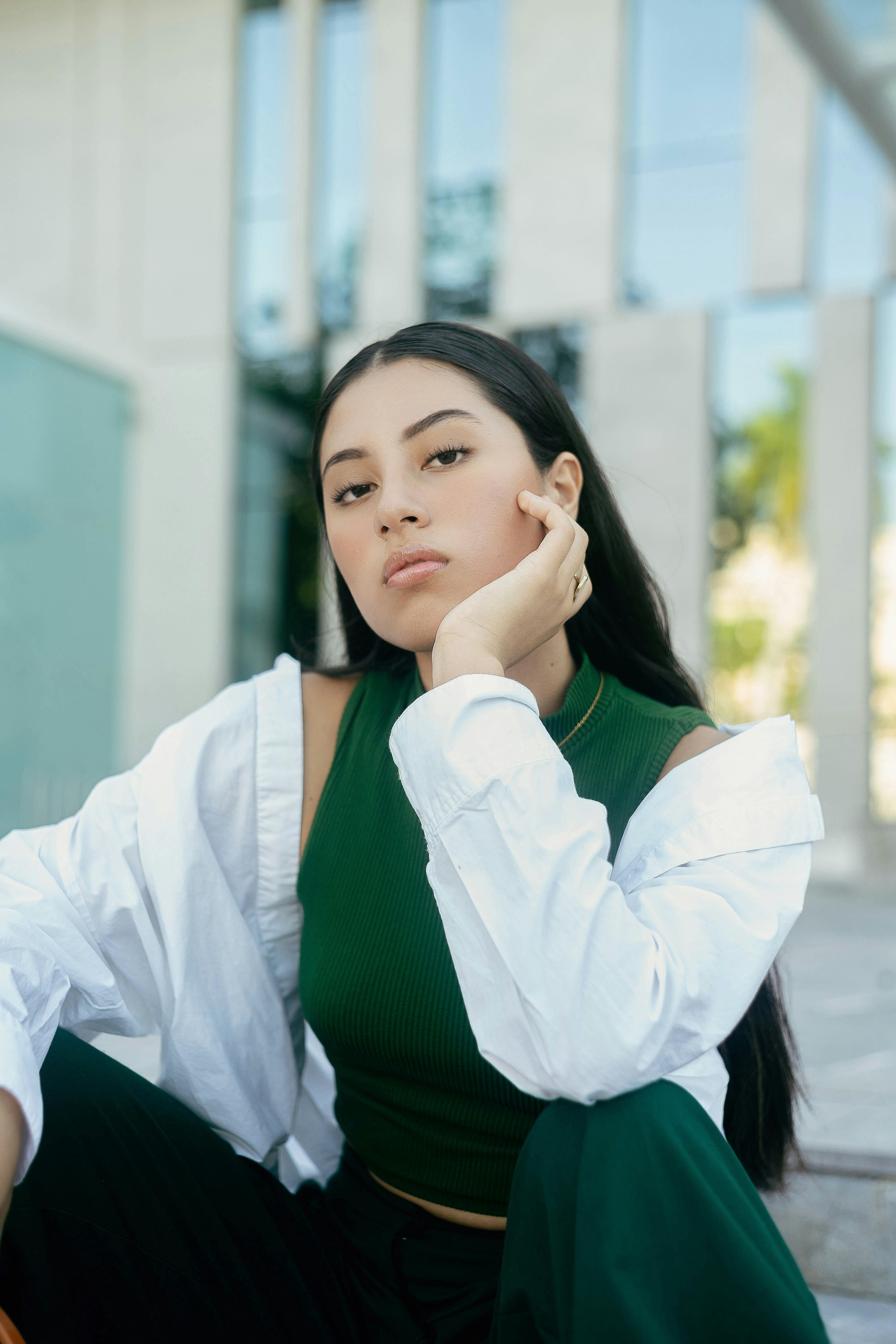Portrait of a stylish woman in Mérida, Mexico, posing outdoors with modern architecture.