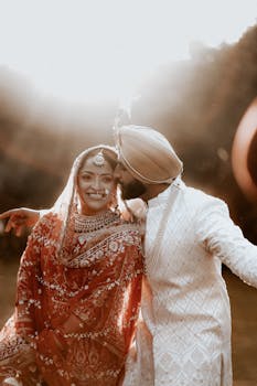 Beautiful Indian couple in traditional attire during sunset wedding ceremony in Tajpur, India.