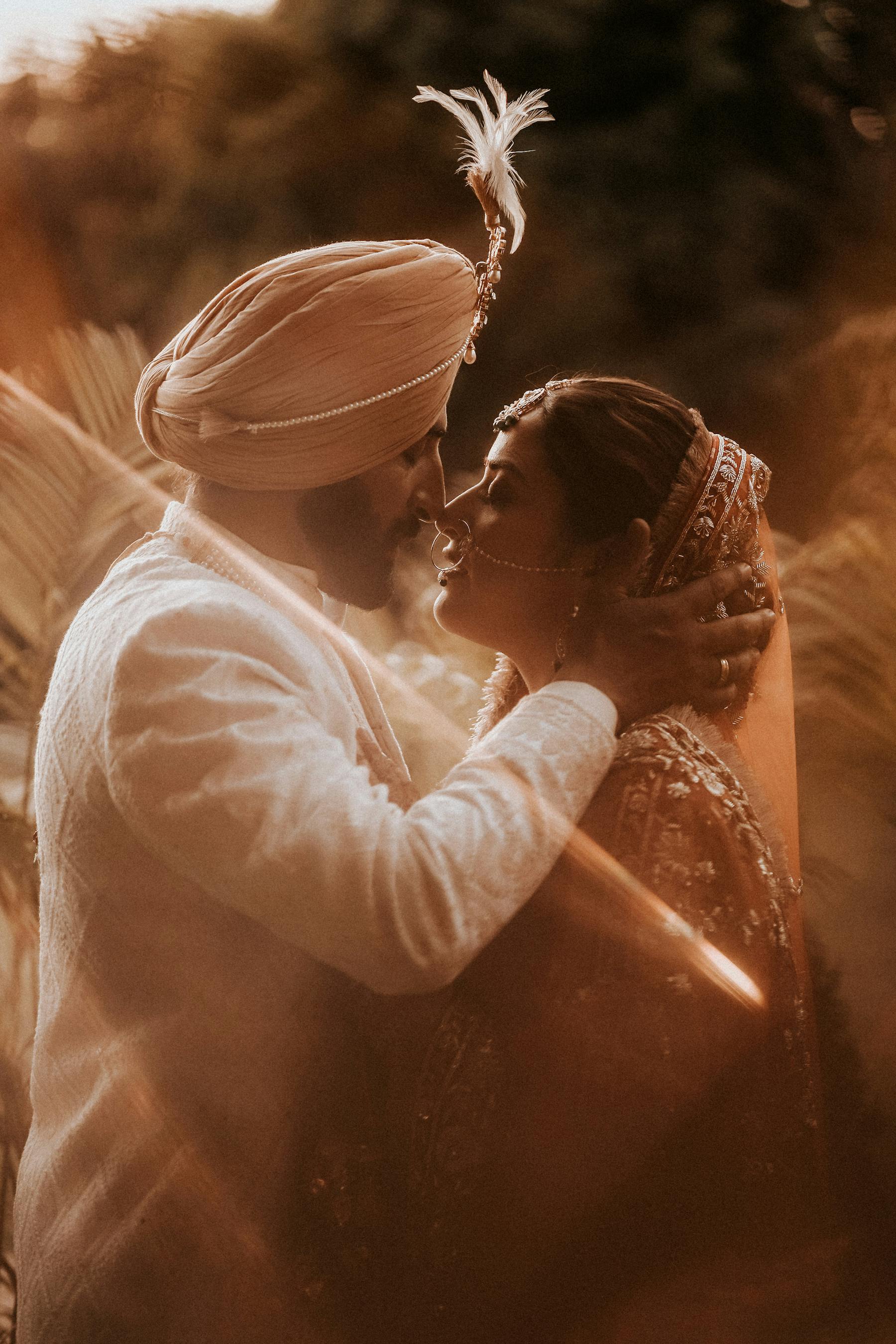 newlyweds in traditional clothing standing and kissing