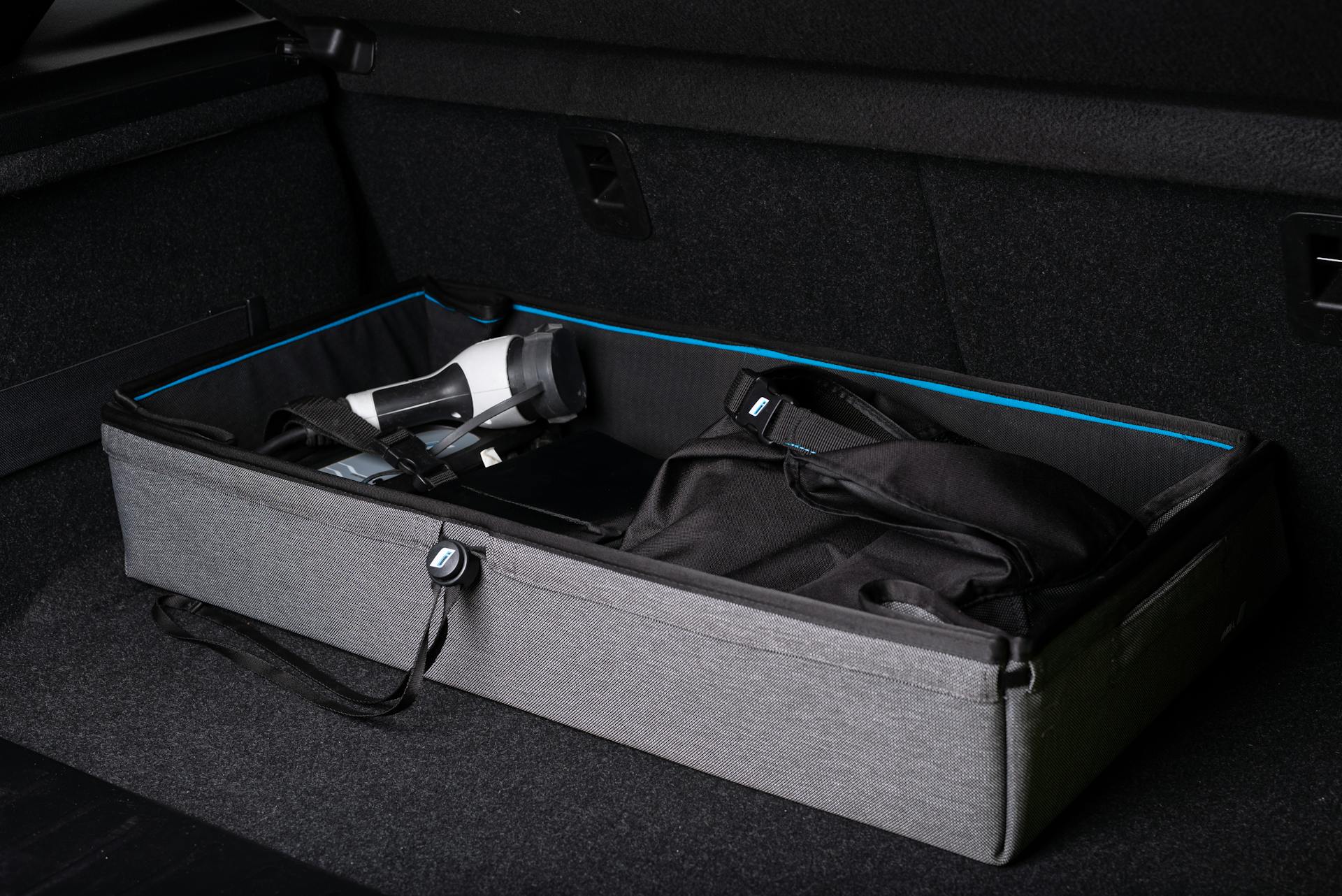 Efficient organization in a car trunk with storage box and travel gear.
